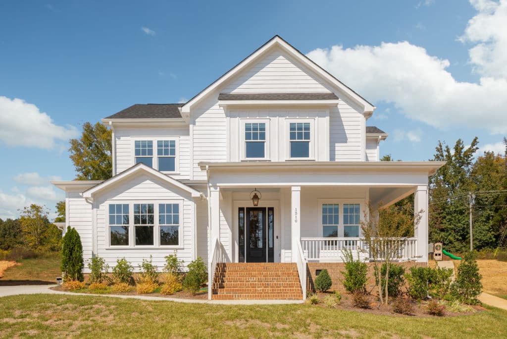 Two-story new home with a covered front porch and large windows
