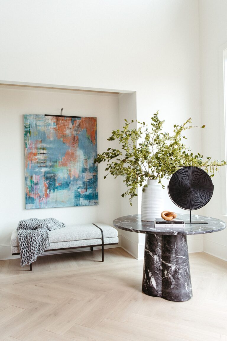 Bright entry with a round marble table in a Copper Builders home