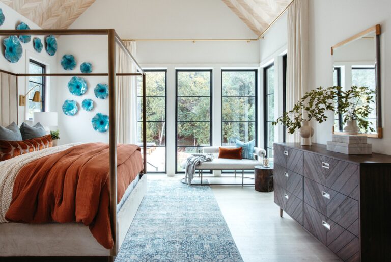 Primary bedroom with a canopy bed and wall of windows