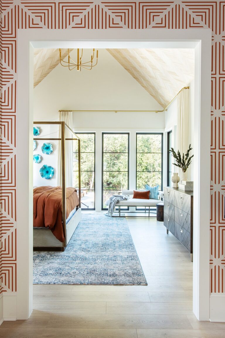 View into a primary bedroom with a vaulted ceiling