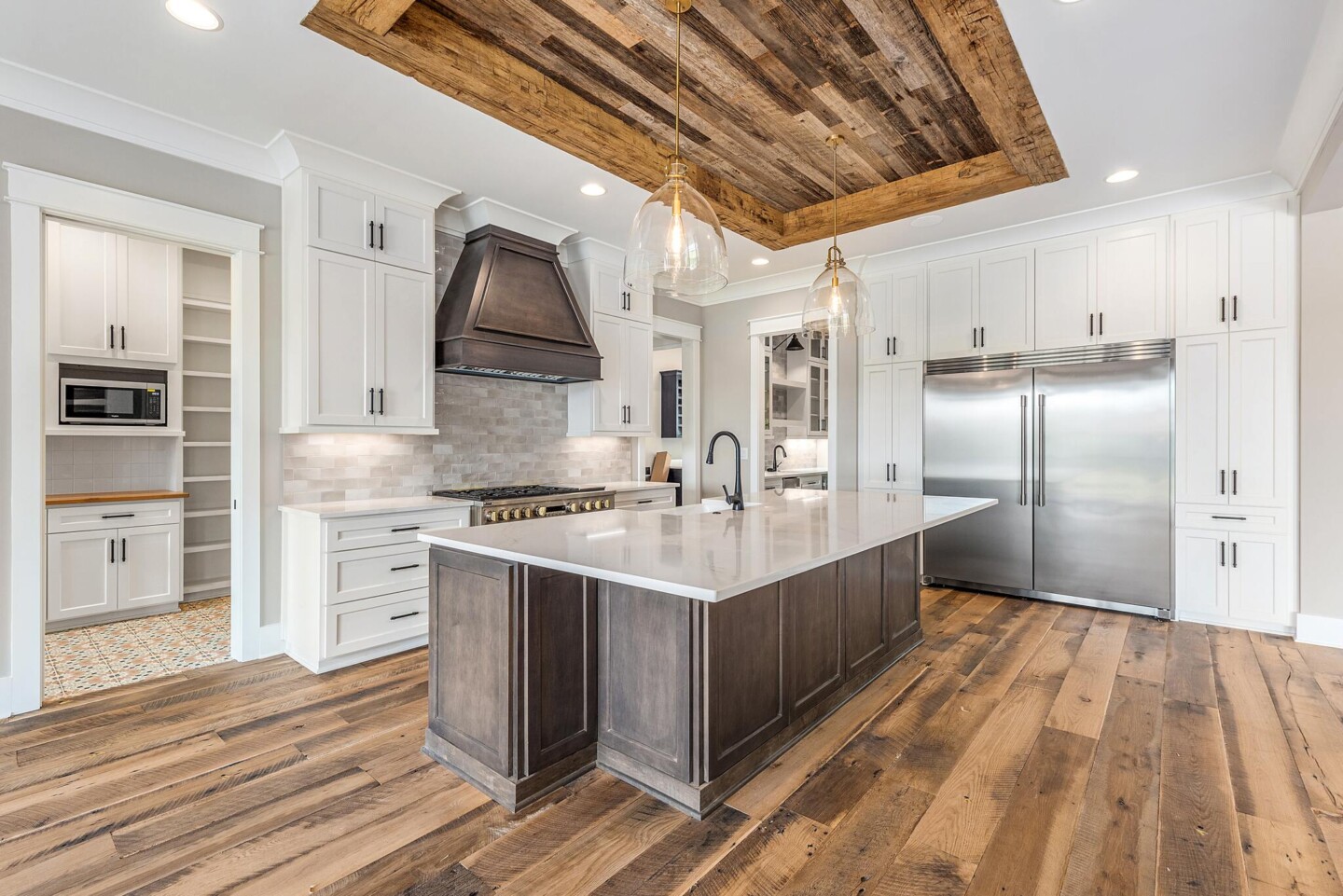 Kitchen with reclaimed wood ceiling, large island and stainless appliances