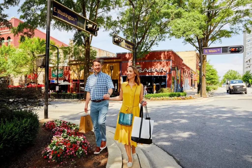 Couple walking along a tree-lined street near new homes in Greenville, South Carolina
