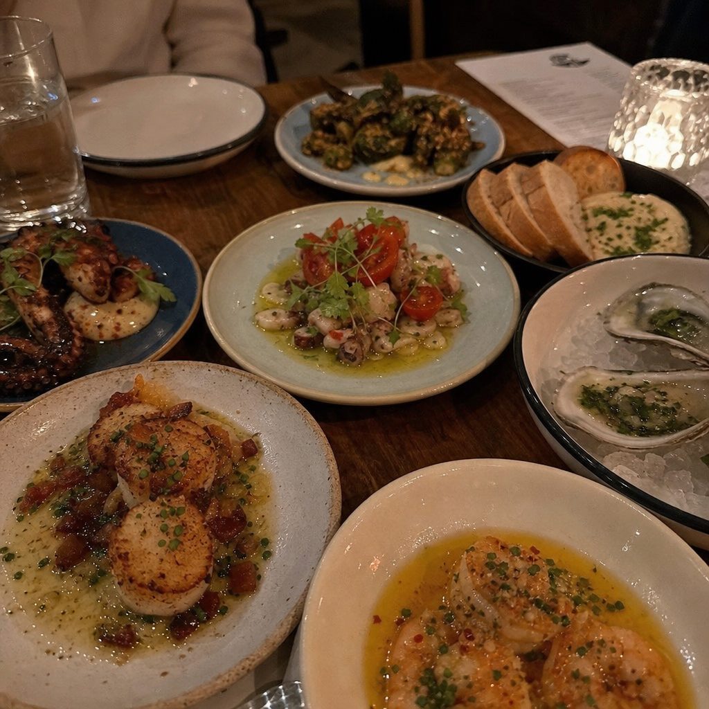 Shared plates and oysters on a table at a Charlotte restaurant