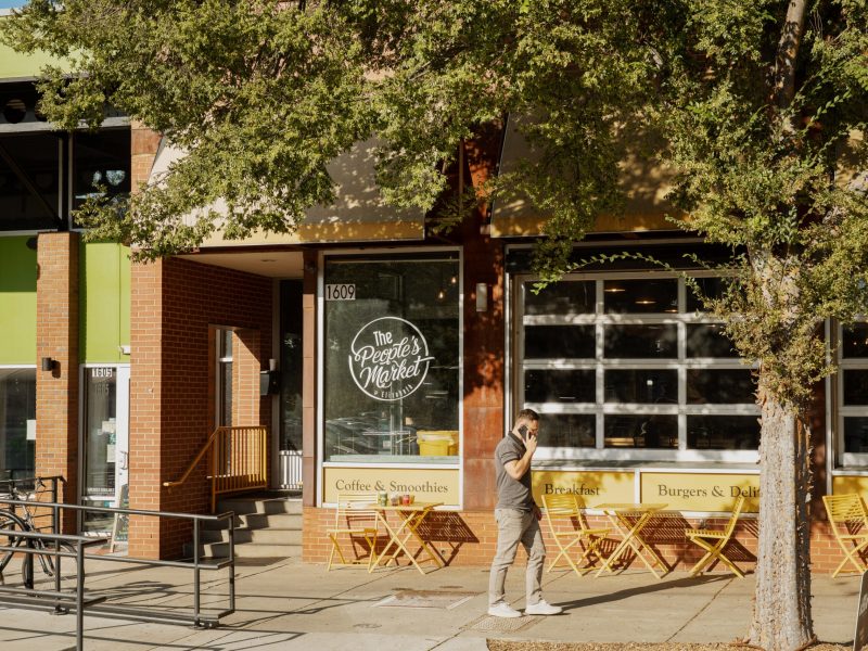 Woman walking past a neighborhood cafe in Charlotte