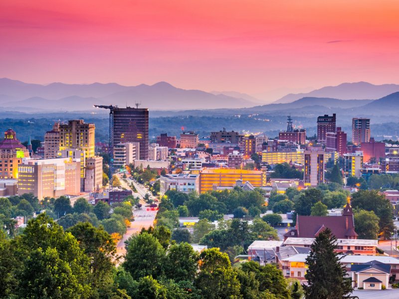 Downtown Asheville skyline with mountains at sunset