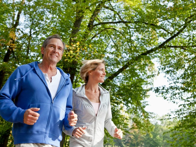 Couple jogging on a wooded trail near Asheville